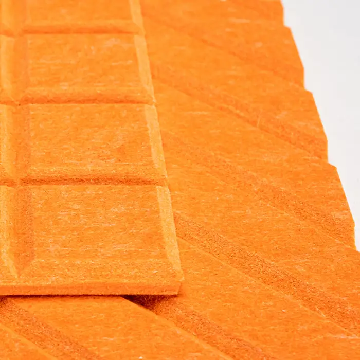British Felt Close-up of orange, textured acoustic panels arranged in a geometric pattern on a flat surface.